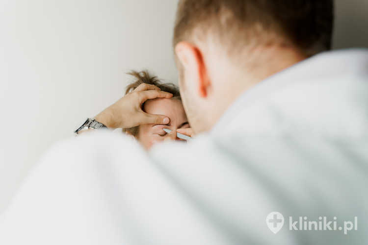 Chirurg plastyczny rysuje na powiece pacjentki linie do cięcia przed zabiegiem blefaroplastyki