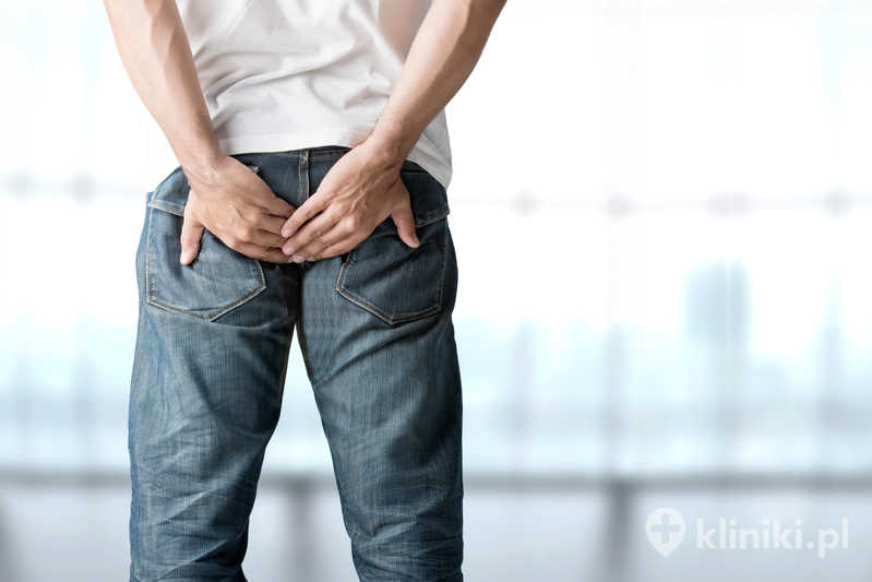 Mężczyzna trzyma się za bolące z powodu żylaków odbytu pośladki Mężczyzna trzyma się za bolące z powodu żylaków odbytu pośladki