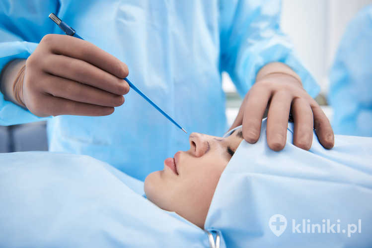 Młoda kobieta leżąca na stole chirurgicznym przed zabiegiem rhinoplastyki