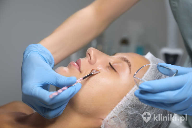 Kosmetolog nakładający produkt do peelingu chemicznego pod oczy Kosmetolog nakładający produkt do peelingu chemicznego pod oczy