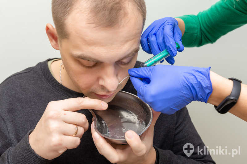 Pielęgniarka przepłukuje nos pacjentowi roztworem soli fizjologicznej