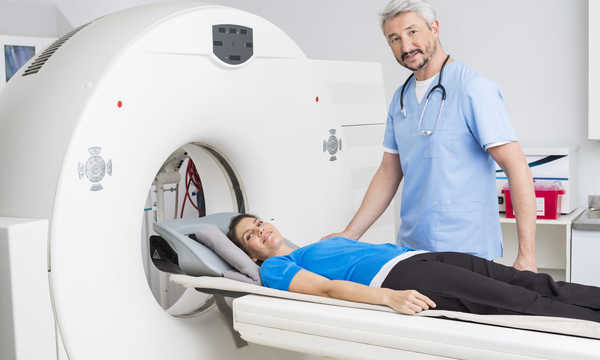 Lekarz stojący przy pacjencie leżącym na aparacie MRI w szpitalu
