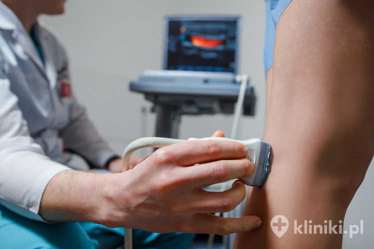 Ortopeda lekarz robi badanie ultrasonograficzne żył nóg pacjenta