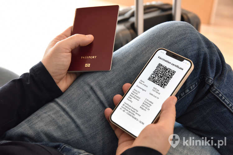 Mężczyzna posiadający paszport i telefon komórkowy z cyfrowym świadectwem szczepienia