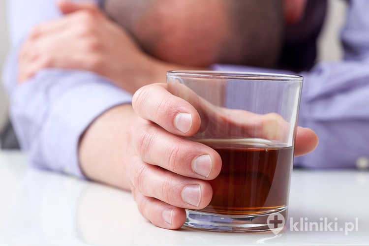 Zbliżenie przygnębionego alkoholika trzymającego szklankę whisky