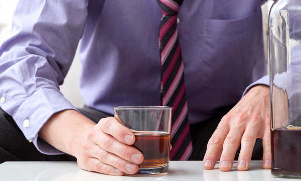Człowiek z problemem alkoholowym po ciężkim dniu w pracy