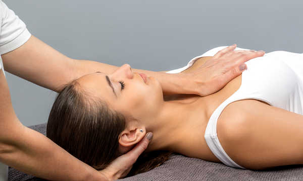 Kobieta poddawana leczeniu osteopatycznemu szyi