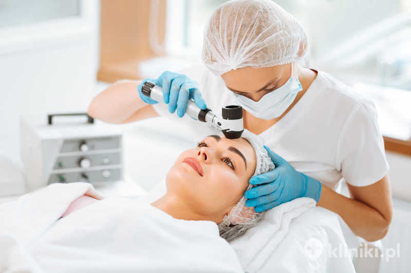 Wykwalifikowana dermatolog trzymająca dermatoskop podczas pracy z pacjentem