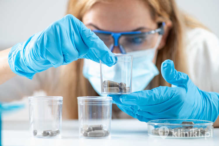 Naukowiec trzyma w laboratorium kapsułki do przeszczepu kału