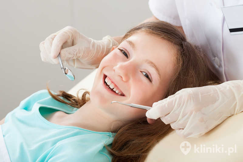 Portret szczęśliwej dziewczynki poddawanej leczeniu stomatologicznemu w klinice Portret szczęśliwej dziewczynki poddawanej leczeniu stomatologicznemu w klinice