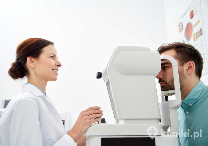 Optometrysta z tonometrem bezkontaktowym sprawdzający ciśnienie wewnątrzgałkowe pacjenta w klinice okulistycznej