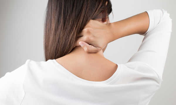 Młoda kobieta cierpiąca na ból pleców i szyi