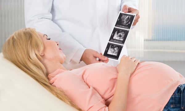 Lekarz pokazujący badanie USG kobiecie w ciąży