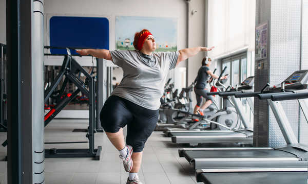 Otyła kobieta na treningu w klubie sportowym