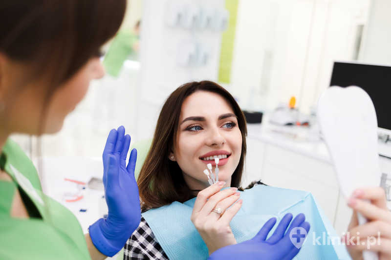 Dziewczyna wybiera kolor licówek w gabinecie dentystycznym Dziewczyna wybiera kolor licówek w gabinecie dentystycznym