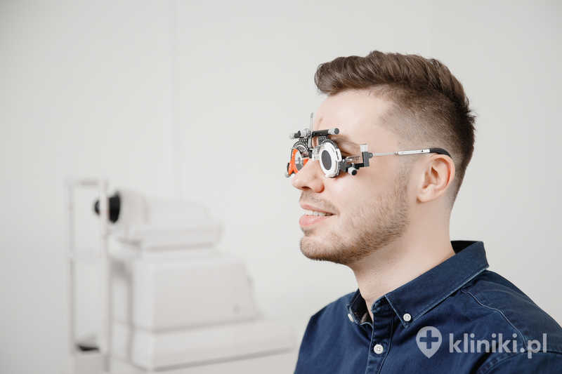 Lekarz okulista sprawdza i diagnozuje krótkowzroczność, nadwzroczność młodego mężczyzny Lekarz okulista sprawdza i diagnozuje krótkowzroczność, nadwzroczność młodego mężczyzny