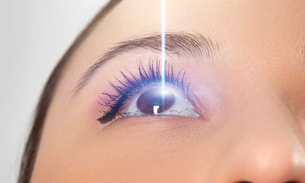 Zbliżenie oka kobiety. Wiązka laserowa na rogówce Zbliżenie oka kobiety. Wiązka laserowa na rogówce