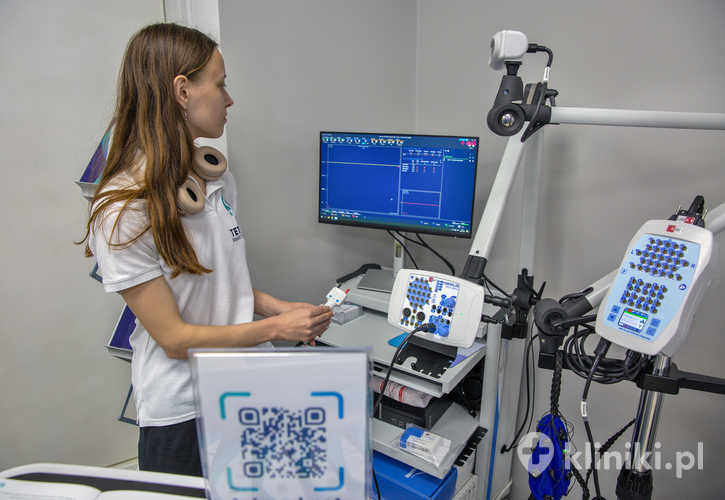 Asystentka medyczna reguluje aparaturę diagnostyczną do badań EEG i EMG