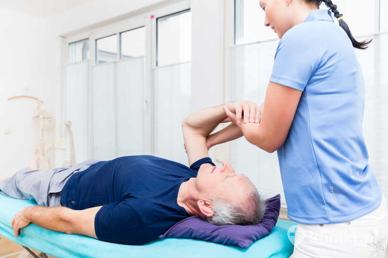 Fizjoterapeuta zajmujący się starszym pacjentem Fizjoterapeuta zajmujący się starszym pacjentem