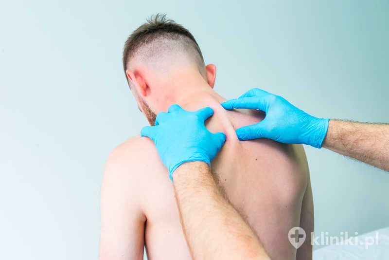 Lekarz neurolog bada odcinek piersiowy kręgosłupa pacjenta w klinice Lekarz neurolog bada odcinek piersiowy kręgosłupa pacjenta w klinice