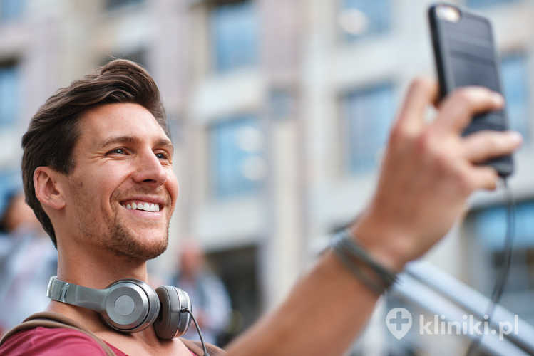 Mężczyzna robi sobie selfie z uśmiechem w mieście – zdjęcie profilowe z podróży, materiał do mediów społecznościowych