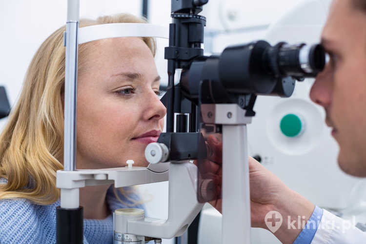 Optometrysta badający pacjentkę przy użyciu lampy szczelinowej w klinice okulistycznej