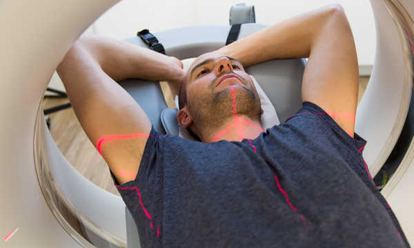 Pacjent poddany badaniu tomografii komputerowej (TK) w pracowni radiologicznej Pacjent poddany badaniu tomografii komputerowej (TK) w pracowni radiologicznej
