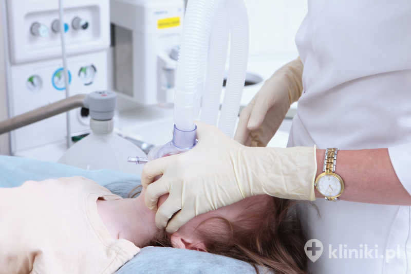 Przygotowanie do zabiegu. Dziecko znajduje się w znieczuleniu ogólnym. Na twarz zakładana jest maska oddechowa Przygotowanie do zabiegu. Dziecko znajduje się w znieczuleniu ogólnym. Na twarz zakładana jest maska oddechowa