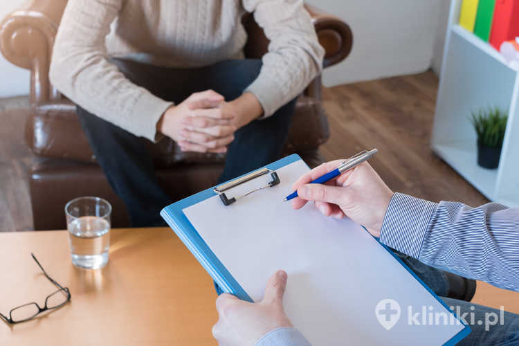 Psycholog robiący notatki podczas sesji psychoterapii