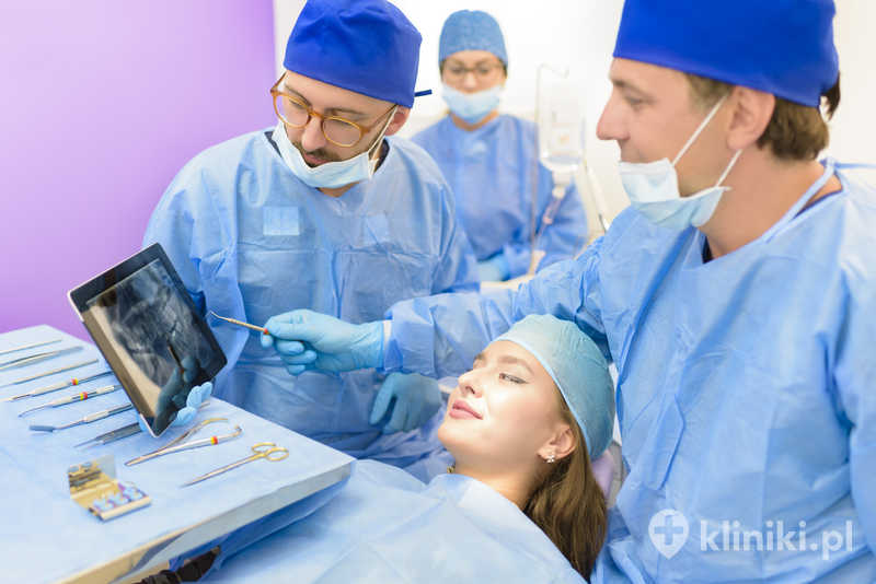 Zespół stomatologiczny analizuje zdjęcie rentgenowskie młodej, pięknej pacjentki