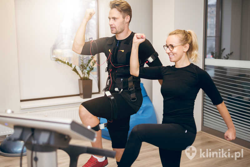 Profilowy portret sportowca wykonującego trening EMS z trenerem personalnym Profilowy portret sportowca wykonującego trening EMS z trenerem personalnym