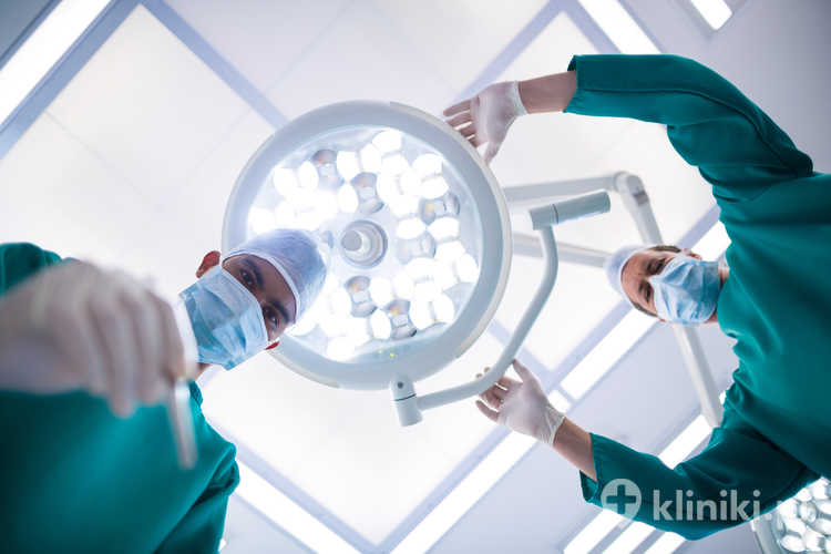 Chirurdzy na sali operacyjne w trakcie zabiegu powiększania piersi implantami